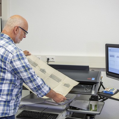 Man scant document in. Afbeelding voor het thema digitalisering van je collectie