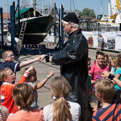 Man die verkleed is met groep kinderen om hem heen