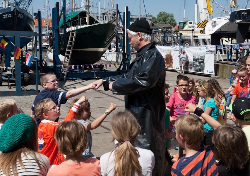 Man die verkleed is met groep kinderen om hem heen