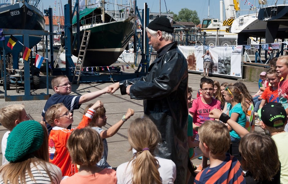 Man die verkleed is met groep kinderen om hem heen