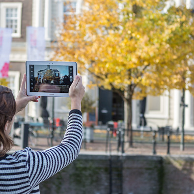 Vrouw maakt foto met tablet in de stad