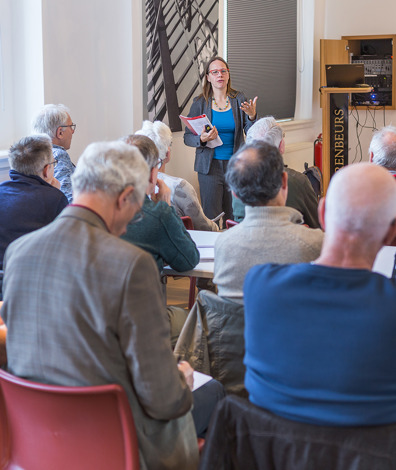 Vrouw vertelt verhaal voor groep mensen die op stoelen zitten