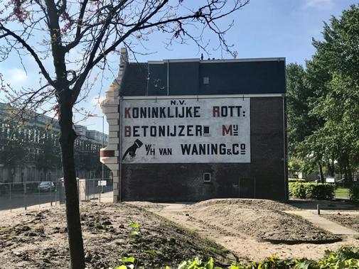 Zijaanzicht van villa Waning met promotietekst op muur