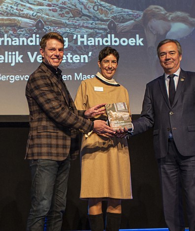 Evelien Masselink en Frank Bergevoet reiken het eerste exemplaar van Handboek Ordelijk Vergeten uit aan gedeputeerde Meindert Stolk. Foto: Floris Scheplitz