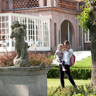 Vrouw wijst haar kind een beeld aan