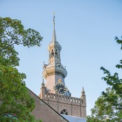 Kerktoren met spits dak en grote klok