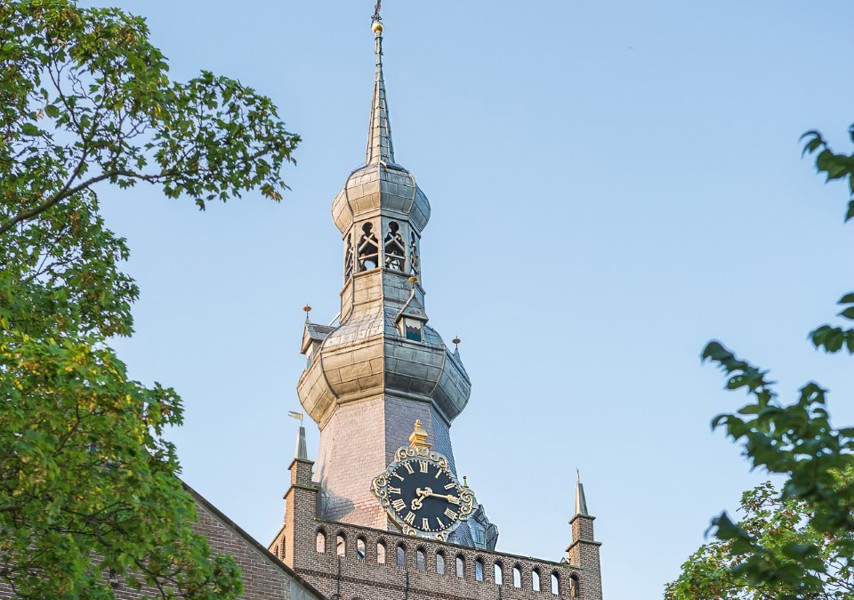 Kerktoren met spits dak en grote klok