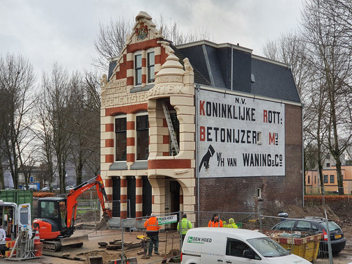 Zijaanzicht van villa Waning met promotietekst op muur