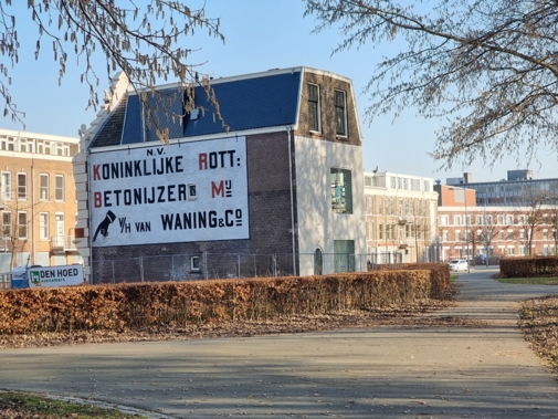 Zijaanzicht van villa Waning met promotietekst op muur