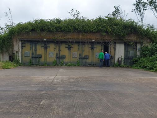 Twee mensen openen een deur in een munitiebunkers