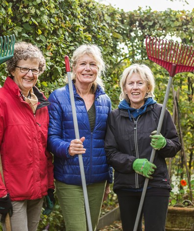 Vrouwen met harken staan bij heg op Landgoed Buitenplaats Huygens